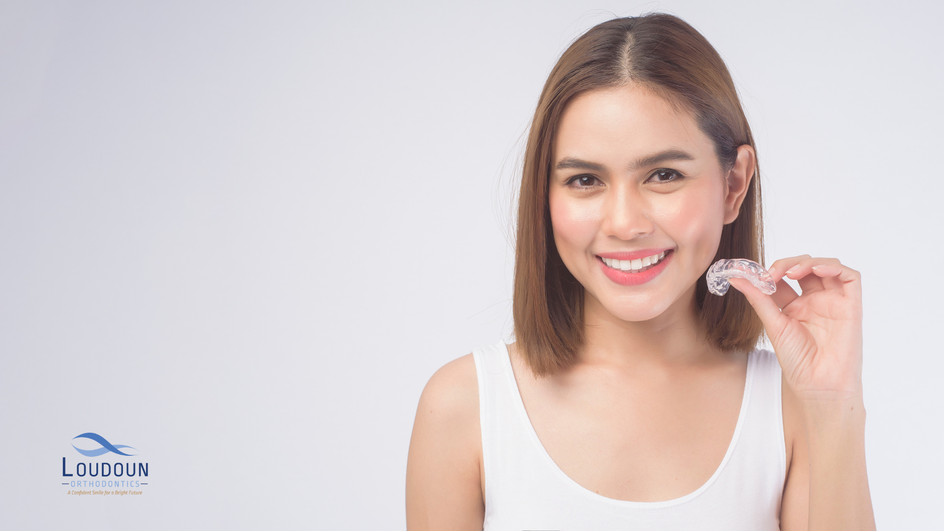 Woman holding an Invisalign retainer