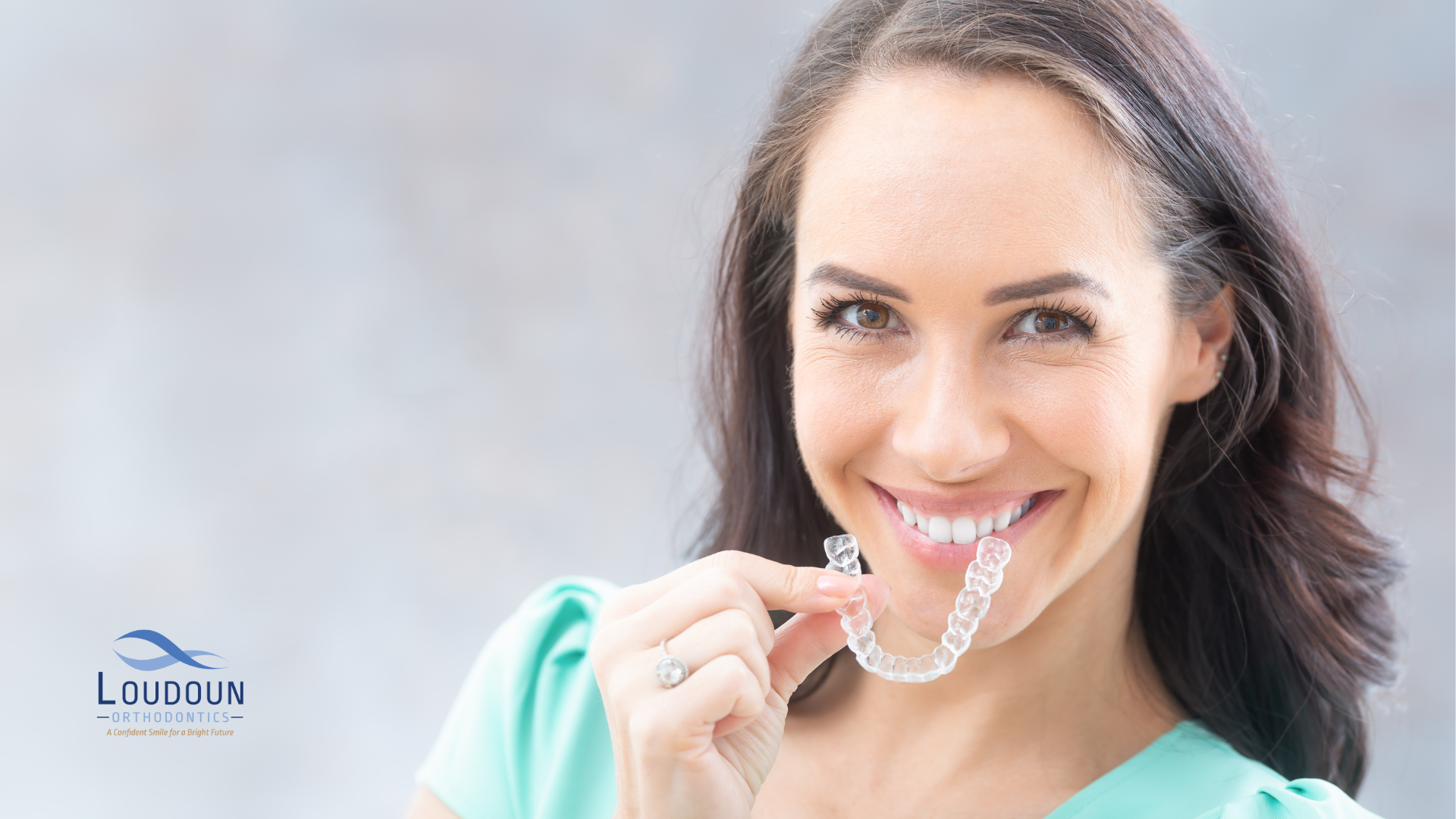 Woman holding an Invisalign retainer